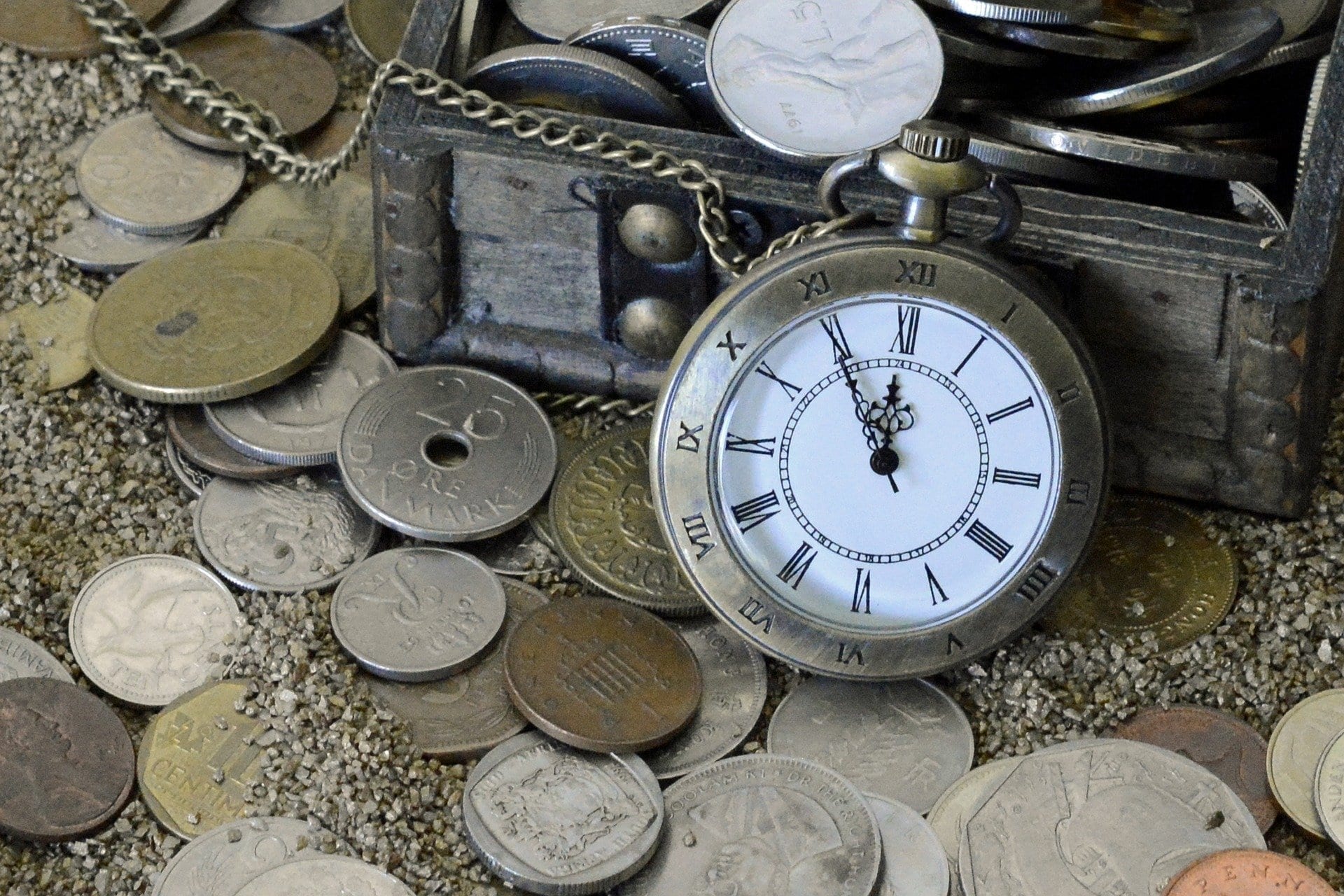 pocket watch on top of coins