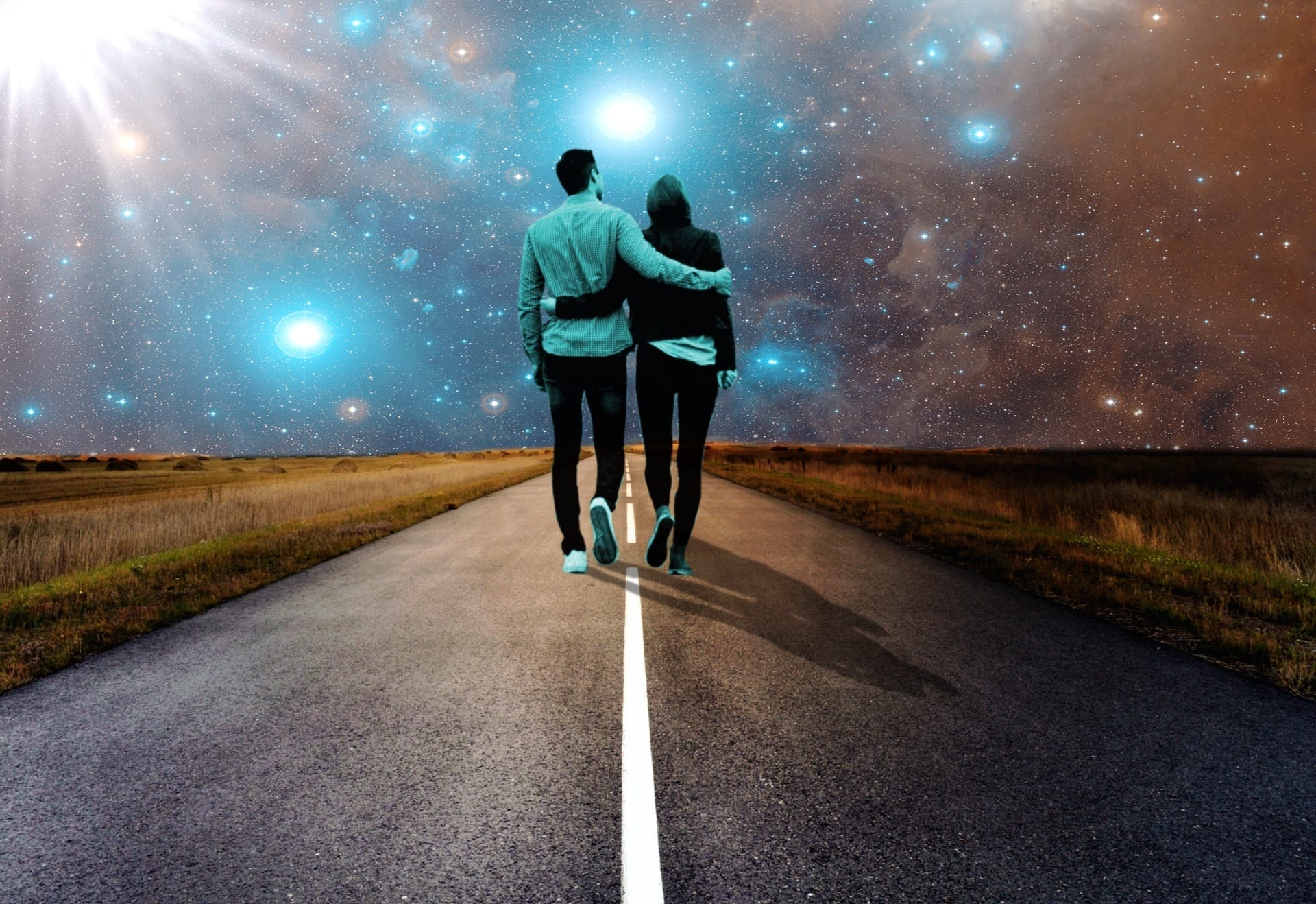 Couple walking on open road under star-lit sky