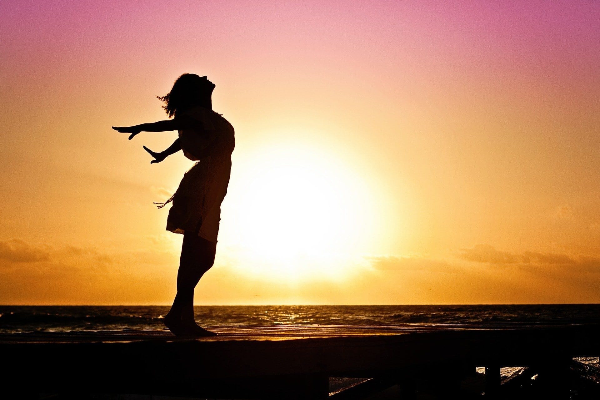 Happy woman standing on beach during sunset