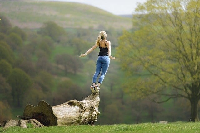 woman meditating on a log
