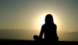woman using the law of attraction meditation at sunset
